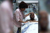 Mary Johnson ora por seu marido, Robert, enquanto estava no hospital. (Captura de tela CBN News)
