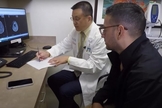Israel Lemus e o médico oncologista Jay-Jiguang Zhu. (Foto: Captura de tela/YouTube Khou 11)