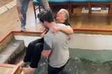Suzan sendo retirada da piscina batismal após batismo. (Foto: Captura de tela/Twitter Ryan Burton King)