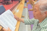 Zheng Yuzhen lendo sua Bíblia nova. (Foto: Reprodução/Bible Society/UBS-CP)