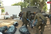 Corpos dos moradores do kibutz Kfar Aza são retirados por policiais israelenses. (Captura de tela/YouTube i24News)