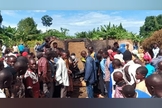 Moradores reunidos em frente à casa queimada do pastor Mukisa. (Foto: Morning Star News).