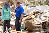 Um capelão orando com uma mulher que perdeu tudo após um tornado. (Foto: Reprodução/BGEA)