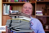 Don Ashley mostra os cadernos preenchidos à mão durante seu projeto de copiar todo o Novo Testamento. (Foto: CBN News)