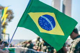 Bandeira do Brasil é erguida durante manifestação popular. (Foto: Pexels)