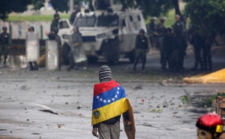 Manifestante de frente para as Forças Armadas em protesto contra Nicolás Maduro, na Venezuela. (Foto: Reuters/Carlos Garcia Rawlins)