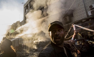 Bombeiros combatem chamas após explosão de carro-bomba na cidade de Qamishli, na Síria. (Foto: Baderkhan Ahmad/AP)