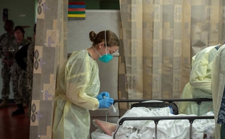 Mulher trata paciente em hospital no navio USNS Mercy, implantado para tratar pacientes com Covid-19 na Califórnia. (Foto: US Navy/Erwin Jacob Miciano/Reuters)