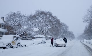 Pessoas tentam tirar veículo do meio de estrada em Lake Michigan Drive, no Michigan, na terça-feira (18) (Foto: AP Photo/The Grand Rapids Press, Joel Bissell )