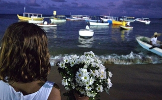 Menina entrega flores como oferenda para Iemanjá, ícone do candomblé. (Foto: Max Haack/Ag. Haack)