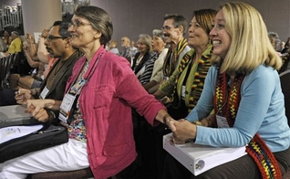Mulheres sorriem diante da aprovação da ordenação de gays e lésbicas na PCUSA. (AP Images/Jim Mone)