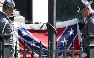 Guardas retiram bandeira confederada dos jardins do Capitólio. (AP Photo/John Bazemore)