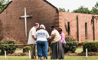 Grupo orando próximo às ruínas da igreja Mount Zion, na Carolina do Sul. (Sean Rayford/Getty Images)