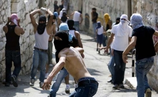 Jovens palestinos atiram pedras contra forças israelenses em Jerusalém (Foto: AFP)