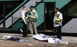Forças de segurança israelenses conversam ao lado de corpo após ataque a tiros contra um ônibus próximo ao bairro palestino de Jabal Mukaber, em Jerusalém Oriental. (Foto: Thomas Coex/AFP)