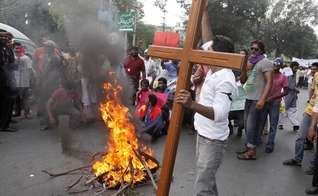 Membro da comunidade cristã paquistanesa segura uma cruz durante um protesto para condenar ataques contra igrejas. (Foto: Reuters/Mohsin Raza)