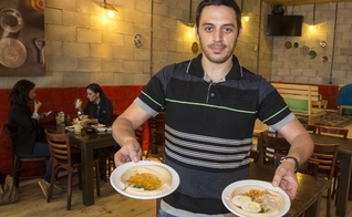 Kobi Tzafrir é o proprietário do Café 'Hummus Bar', em Kfar Vitkin, região central de Israel (Foto: AFP)
