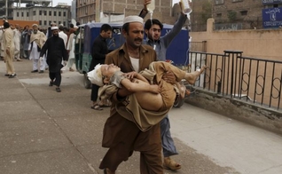 Homem carrega garoto ferido, após o terremoto, em Peshawar, no Paquistão (Foto: Reuters)
