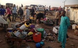 Cidadãos nigerianos buscam pertences em meio aos escombros de uma explosão provocada por terroristas, na cidade de Adamawa. (Foto: Reuters)