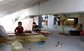 Crianças cristãs que fugiram da violência do Estado Islâmico em Qaraqosh, descansam sobre colchões velhos, em prédio abandonado, na região de Arbil - norte de Bagdá. (Foto: Reuters)