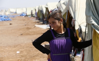 Após conseguir fugir de cativeiro do Estado Islâmico, garota yazidi permanece em frente à sua tenda, em um campo de refugiados na fronteira entre Curdistão e Síria (Foto: Youssef Boudlal / Reuters)