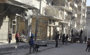 Moradores perto de edifícios danificados na vila de Kafr Hamra, no norte rural de Aleppo, Síria (27 de fevereiro de 2016). Foto: Reuters.