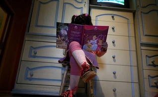 Lulu, uma 'menina' transgênero, lê um livro em seu quarto em sua casa em Buenos Aires. (Foto: Reuters)