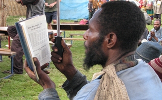Morador de Papua Nova Guiné lê a Bíblia. (Foto: Joy Ellen)