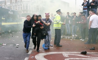 Imagem registrou momento em que Paul Sanderson (à direita) e outro homem ajudaram mãe e filho a fugir do tumulto gerado por torcedores antes de um jogo de futebol na Inglaterra. (Foto: Reuters)