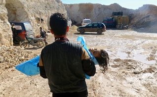 Homem carrega o corpo de uma criança morta após ataque químico em Khan Sheikhoun. (Foto: Ammar Abdullah/Reuters)
