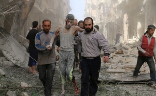Sírios ajudam um jovem ferido após um ataque aéreo em Aleppo. (Foto: Ameer Alhalbi/AFP)