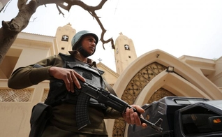 Policial armado em frente à igreja copta que foi bombardeada em Tanta, no Egito. (Foto: Reuters/Mohamed Abd El Ghany)