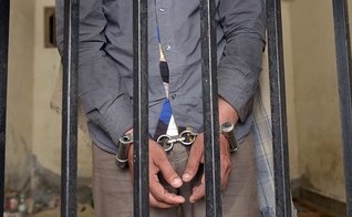 Prisioneiro algemado em cela de penitenciária, no Paquistão. (Foto: AFP)