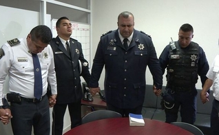Membros da 'Polícia Celestial' se unem para orar, antes de mais uma ação nas corporações. (Foto: Telemetro)