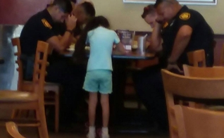 Menina de 8 anos ora por policiais que tiveram companheiro assassinado. (Foto: Reprodução/Facebook)