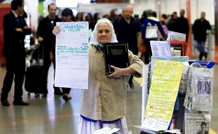 Sem ouvir desde os 38 anos, Dona Isaura carrega a Bíblia e cartazes. (Foto: Rafaela Felicciano/Metrópoles)