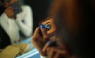 Modelo transexual se maquia antes de se apresentar em Nova Deli, na Índia. (Foto: Reuters/Adnan Abidi)
