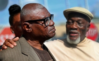Wilbert Jones falando aos repórteres após deixar a prisão ao lado de seu irmão, Plem Jones. (Foto: Gerald Herbert/Associated Press)