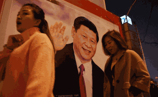 Pessoas passam por foto do presidente Xi-Jinping, exposta em rua da China. (Foto: Breitbart)