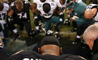 Steve Smith orando com jogadores da Philadelphia Eagles em Baltimore, Maryland. (Foto: Patrick Smith/Getty Images)