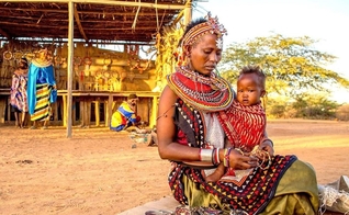 Mulher carrega o filho nos braços em aldeia do Quênia. (Foto: Foundation for Economic Education)