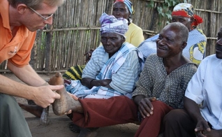 Doutor Arie De Kruijff examinando os pés de um homem com lepra. (Foto: Leprosy Mission)