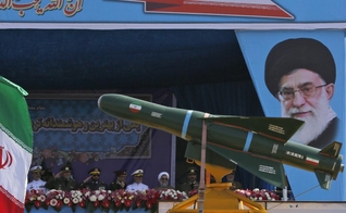 Caminhão militar transportando mísseis diante do retrato do líder supremo do Irã, aiatolá Ali Khamenei. (Foto: Getty Images)