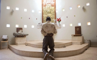 Homem ora diante de altar em igreja, em Uganda. (Foto: Reuters)