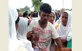 O pai de Anjali Masih sendo confortado por vizinhos. (Foto: WWM)