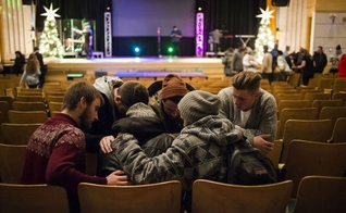 Jovens orando juntos após um culto evangélico em Toronto, no Canadá. (Foto: Christopher Katsarov/The Globe and Mail)