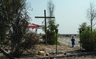 Cruz erguida em uma praça da cidade de Karemlash, no Iraque, devastada por militantes do Estado Islâmico. (Foto: Martyn Aim)