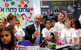 Primeiro-ministro Benjamin Netanyahu junto a crianças em escola. (Foto: Times of Israel)