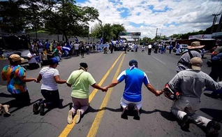 Em manifestação, os cristãos resolveram se ajoelhar e clamar a Deus para que se normalize a situação do país. (Foto: CBN News).