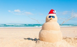 Boneco de areia montado na praia, com caracterização natalina. (Foto: bpcp.org)